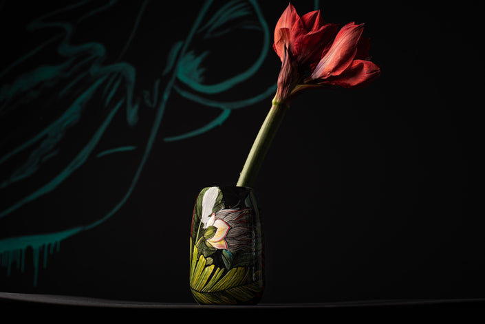 Red flower in a glass vase with a blurred background