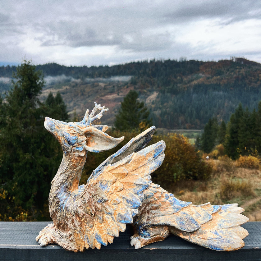 Dragon sculpture with a scenic background of trees and mountains