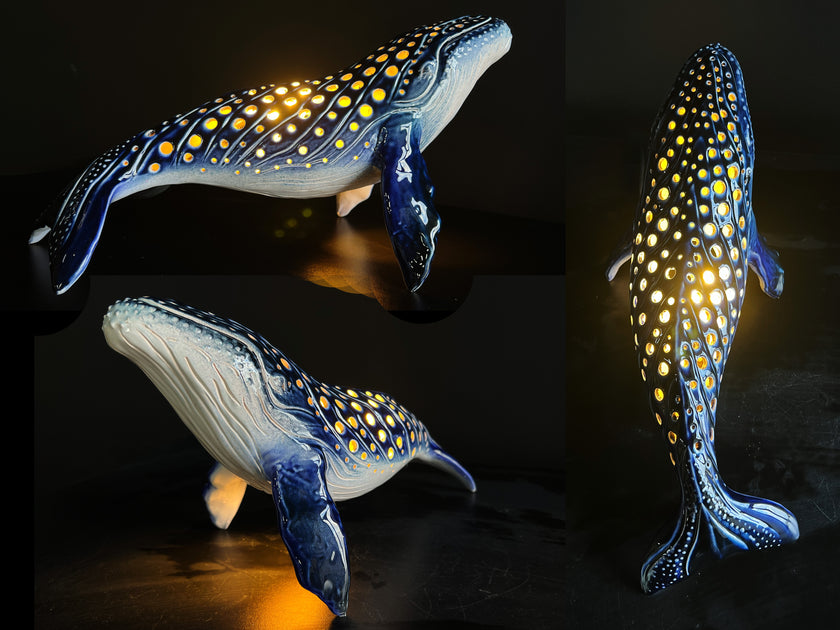 Three whale-shaped lamps with glowing patterns on a dark background