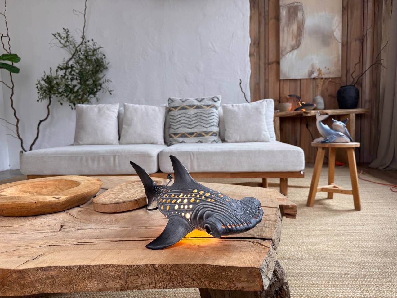 Decorative shark lamp on a wooden coffee table in a living room setting.