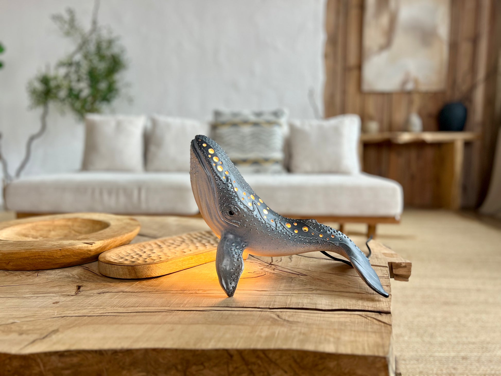 Decorative whale lamp on a wooden table in a living room setting