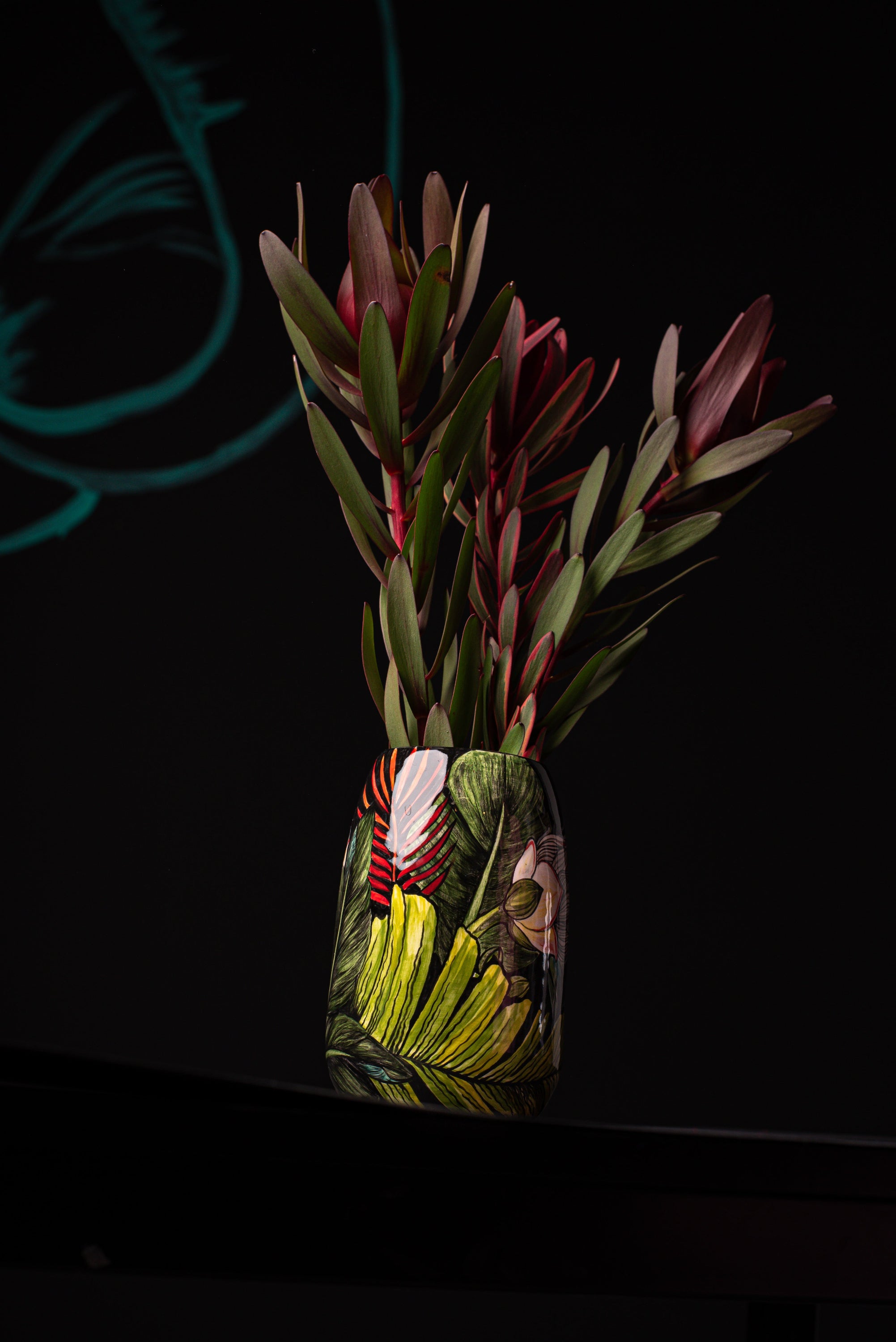 Decorative ceramic vase with plants on a dark background