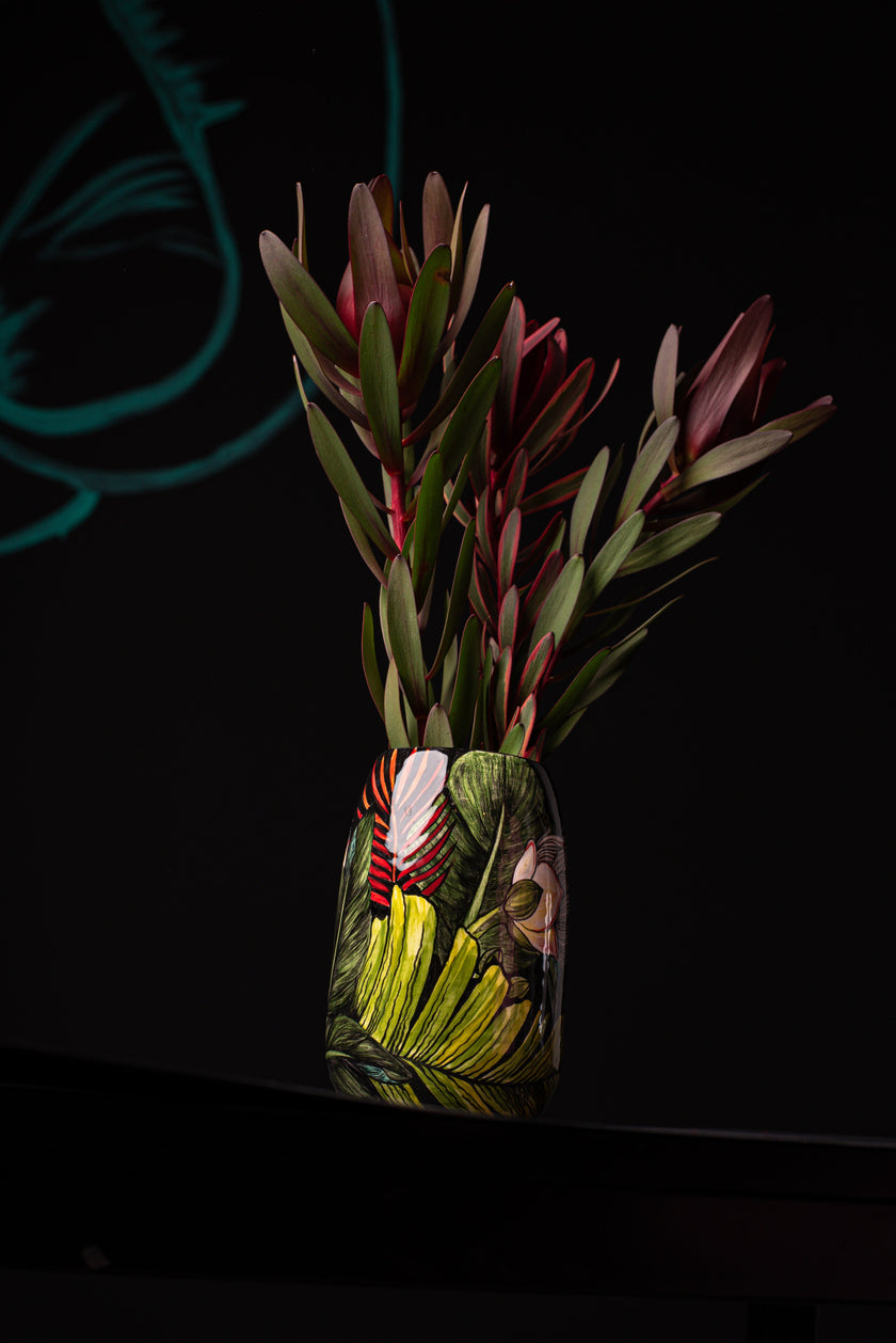 Decorative ceramic vase with plants on a dark background
