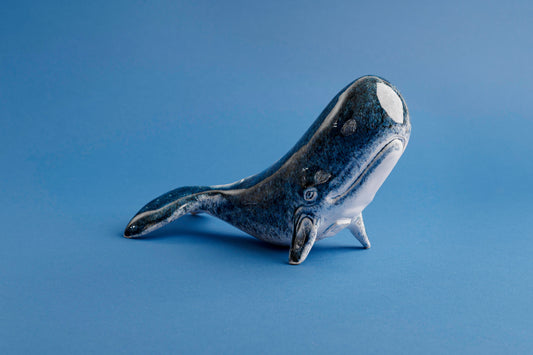 Ceramic whale figurine on a blue background
