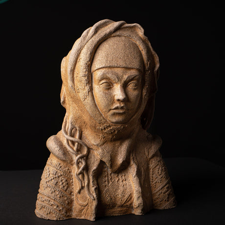 Stone sculpture of a person with a headscarf on a black background