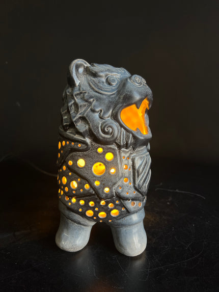 Ceramic figurine with glowing interior on a dark background