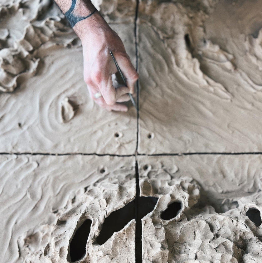 Person using a tool to create patterns on a textured surface